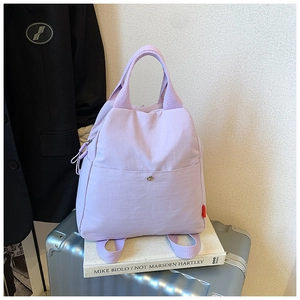 Detail of lavender nylon backpack on a silver suitcase for travel and daily commute