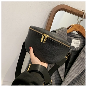 Detail of black lychee grain leather chest bag with golden zippers and nylon strap