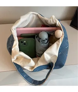 Macro shot showing large storage capacity of blue denim tote bag with white bow pattern
