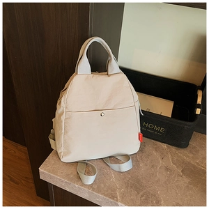 Detail of beige lightweight nylon multi-functional backpack with fashion label and front pocket
