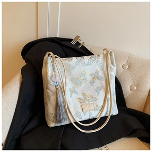 Detail of Hanfu bucket bag featuring elegant blue butterfly embroidery and grey tassel accent