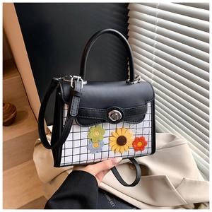 Détail du sac à bandoulière avec broderie de tournesol et fermoir rotatif en métal