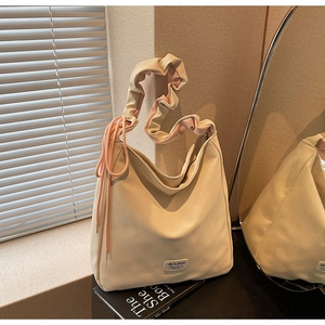 Detail of off-white hobo bag with ruffled handle, pink drawstring and MULAIDI logo