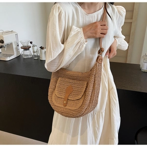 Detail of straw crossbody bag with leather strap and front pocket for summer vacation