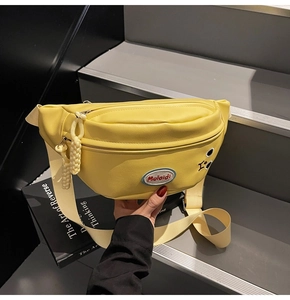 Dettaglio del marsupio giallo con ricamo di occhi a fumetti e patch logo Mulaidi