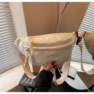 Detail of white canvas crescent fanny pack with embroidered logo and woven zipper pull