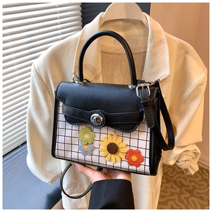 Détail du petit sac bandoulière avec motif à carreaux noir blanc et décor de tournesol