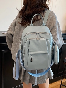 Light blue faux leather backpack with adjustable straps and round coin purse charm