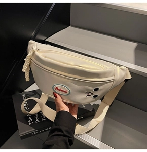 Dettaglio borsa da cintura in pelle crema con ricamo orso ed etichetta logo Mulaidi
