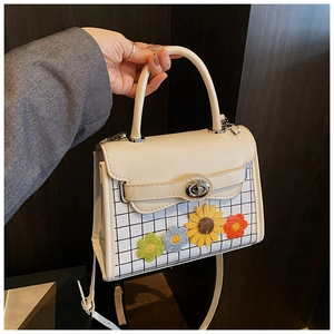 Détail du sac à main en cuir PU crème avec motif à carreaux et fleurs colorées au crochet