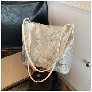 Detail view of light blue jacquard floral fabric and gray tassel on the hanfu tote bag