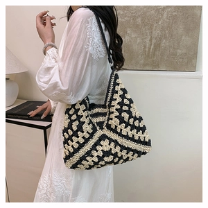 Detail of handmade crochet shoulder bag featuring a black and beige granny square pattern