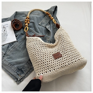Détail du sac à bandoulière beige tissé à la main avec perles en bois et sangle en cuir