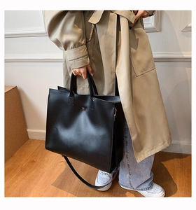 Minimalist black PU leather tote bag with sturdy handles and adjustable shoulder strap