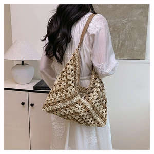 Macro shot of handcrafted woven straw bag featuring beige lattice pattern and leather strap