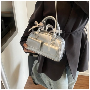 Detail of silver metallic bowling bag with bow and lace ribbons on black blazer