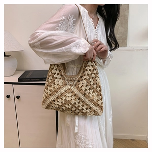 Detail of light brown straw tote bag featuring woven mesh pattern and wavy edges