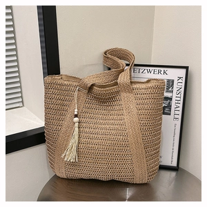 Detailed straw tote bag with a white tassel pendant and wooden bead decoration