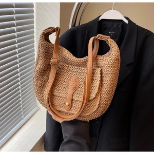 Close-up of woven straw texture and brown leather strap with brass buckle detail