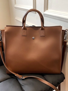 Brown large capacity tote bag with top handles and adjustable shoulder strap for commuting