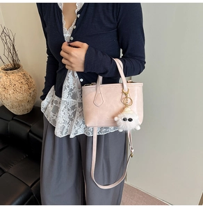 Détail du sac seau en similicuir rose avec lettrage de mode et joli pendentif peluche