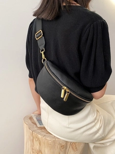 Classic black lychee pattern waist bag with gold zippers and wide strap on model