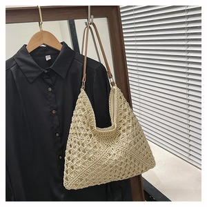 Detailed close-up of beige crochet woven tote bag featuring intricate floral hollow patterns