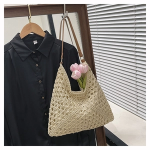 Detail view of beige woven tote bag showing intricate hollow crochet texture and leather strap