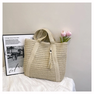 Macro view of woven straw tote bag texture with wooden bead tassel and interior detail