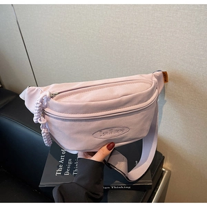 Detail of light purple canvas chest bag showing dual zippers and Muiaiai embroidery
