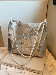 Elegant floral jacquard bucket bag with double straps and a long grey tassel ornament