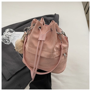 Pink drawstring bucket bag with textured pleats and cute plush teddy bear charm detail