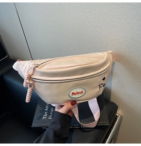 Dettaglio della borsa pettorale in pelle PU rosa con ricami e zip in metallo