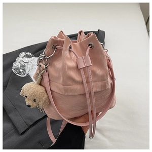 Pink drawstring bucket bag with glossy wrinkled texture and a cute plush puppy pendant