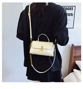 Detailed shot of cream white leather mini square bag with gold metal buckle and chain strap