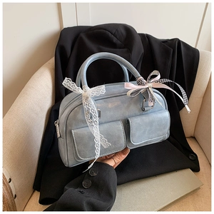 Close-up of light blue bowling bag with lace ribbons and multi-colored bow details