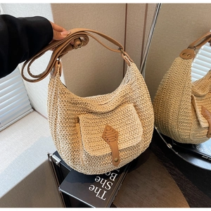 Detail of hand-woven beige hobo bag with brown leather strap and buckle closure