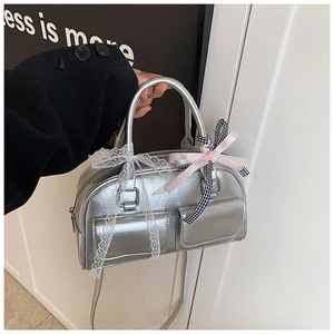 Detailed macro view of silver metallic Boston bag with pocket details and lace bow