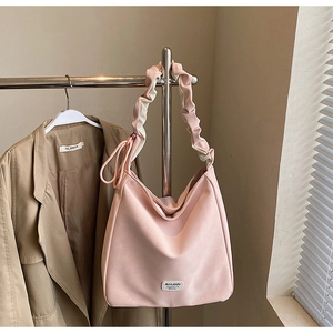 Detail of soft pink tote bag featuring a creative cloud-pleated shoulder strap design