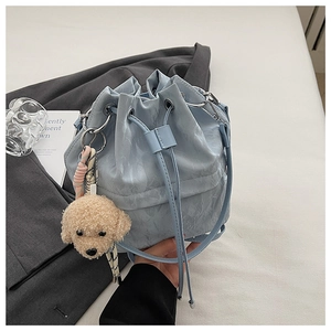 Close-up of light blue drawstring bucket bag with crinkle texture and cute puppy charm