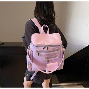 Detailed view of light purple leather backpack with multiple zip pockets on a model