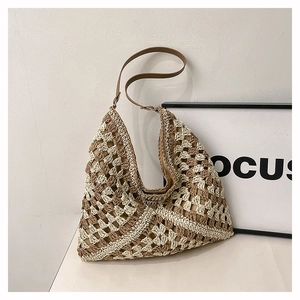 Detail of crochet straw tote with beige contrast weave and brown leather strap