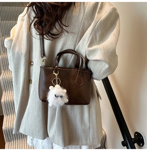 Sac seau en cuir marron foncé avec charme monstre en peluche blanc en look street