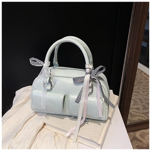 Detail of light mint green bowling bag with decorative bows and multi-pocket features