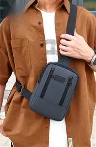 Detail of grey washed denim sports chest bag with multi-zip pockets and SPORT label