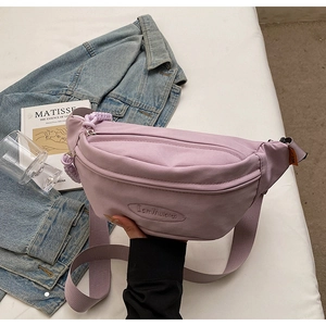 Detail of lavender canvas crossbody chest bag with adjustable strap and logo embossing