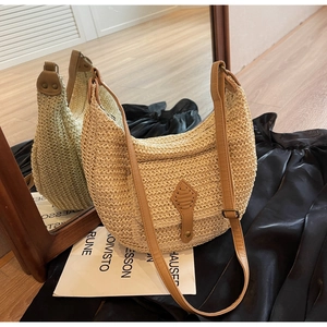 Detail of cream straw crossbody bag with brown leather patch and adjustable strap