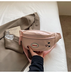 Dettaglio borsa da petto in pelle PU rosa con ricamo cartoon e ciondolo a treccia