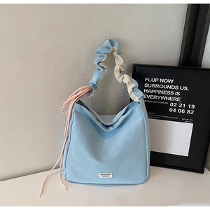Detail of light blue tote bag with unique ruched handles and pink drawstring accents