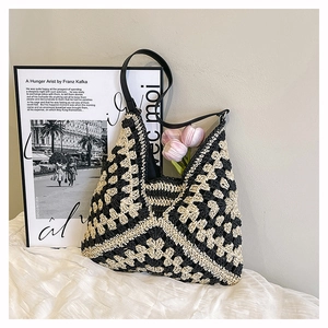 Detail of hand-woven crochet hobo bag featuring black and white geometric textures